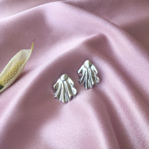 Close-up of silver drape statement earrings with detachable design, made from stainless steel for a tarnish-free shine.