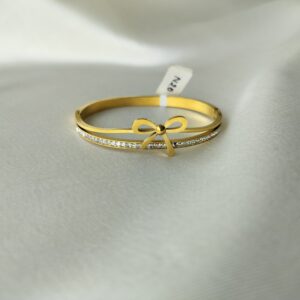 Close-up of delicate gold bow bracelet detailing and crystal quality