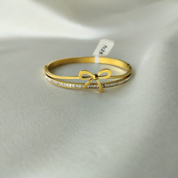 Close-up of delicate gold bow bracelet detailing and crystal quality