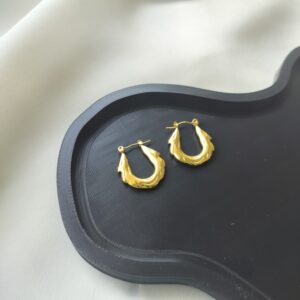Liquid-inspired gold hoop earrings with wavy texture | Nitara Haute