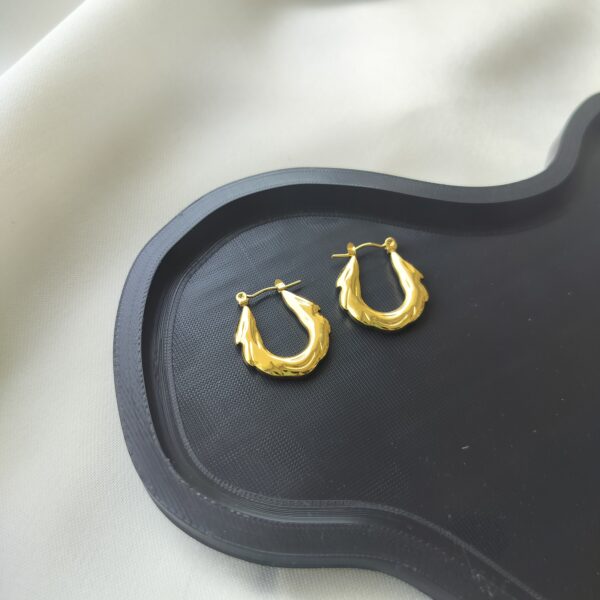 Liquid-inspired gold hoop earrings with wavy texture | Nitara Haute