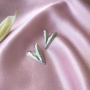 Front view of heart-shaped textured rhodium stud earrings