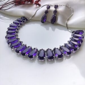 Close-up of purple teardrop glass stones on a silver-tone necklace.