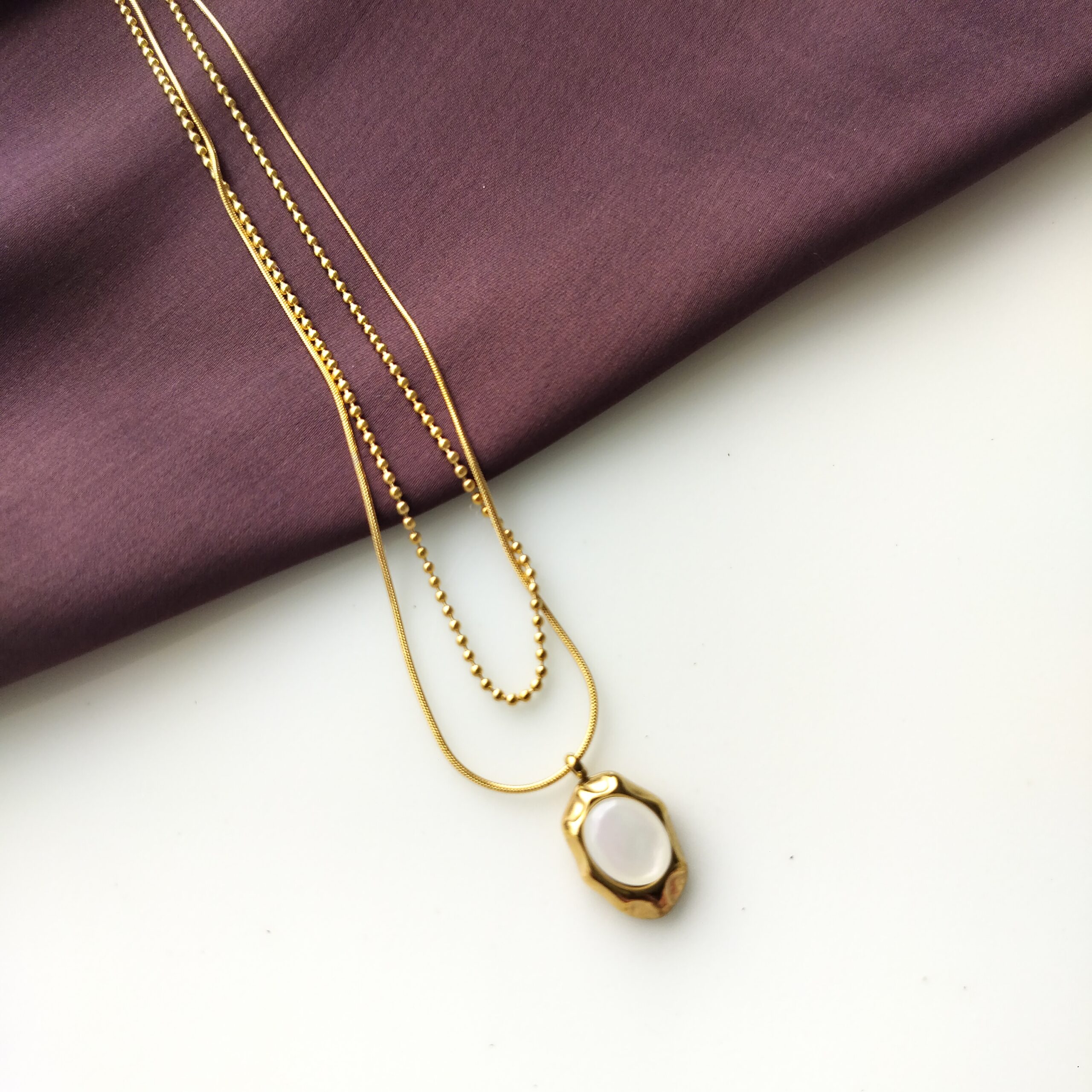 Close up detail of the two different chain designs on the necklace.