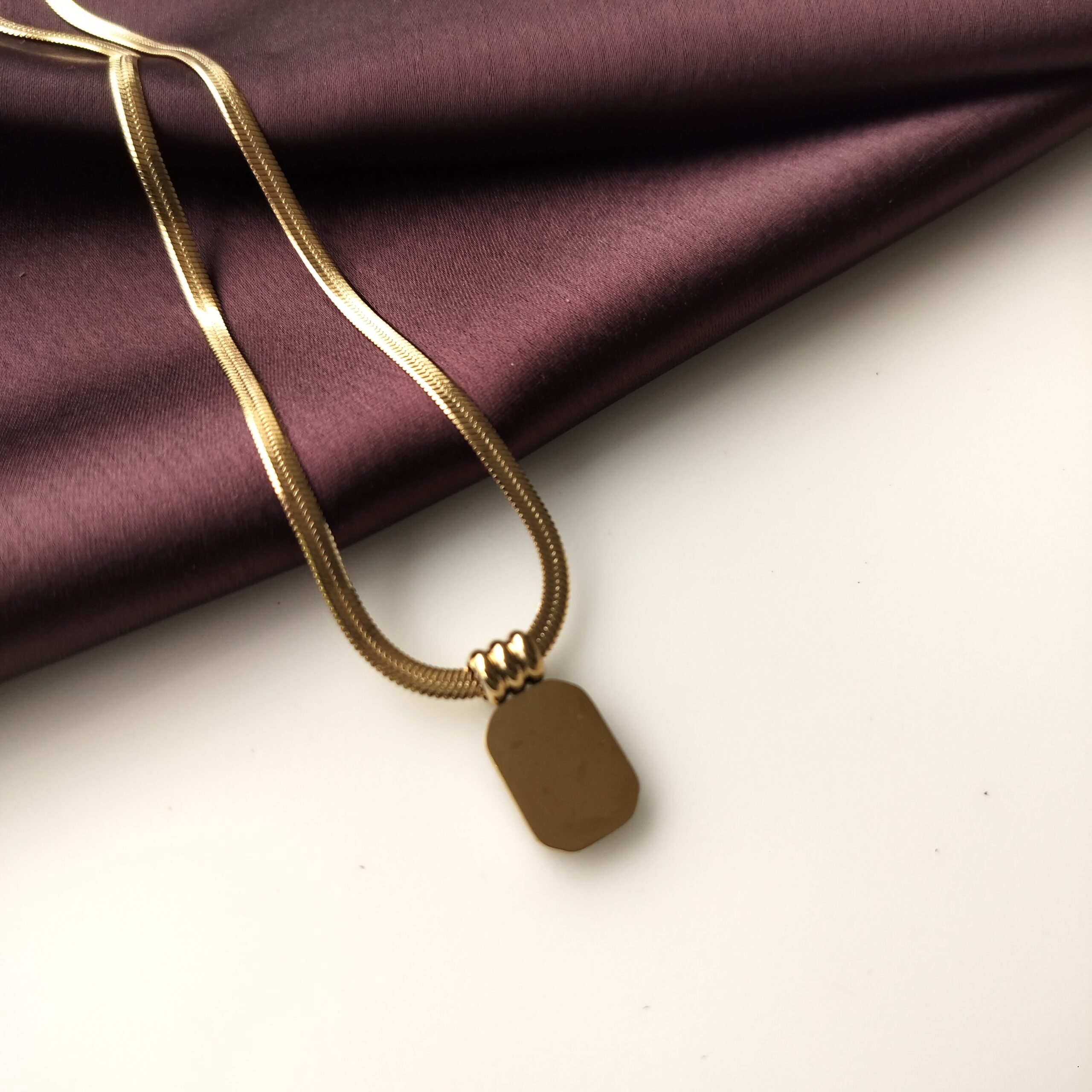 Back of the Black Obsidian Curve Necklace showing smooth gold plated finish.