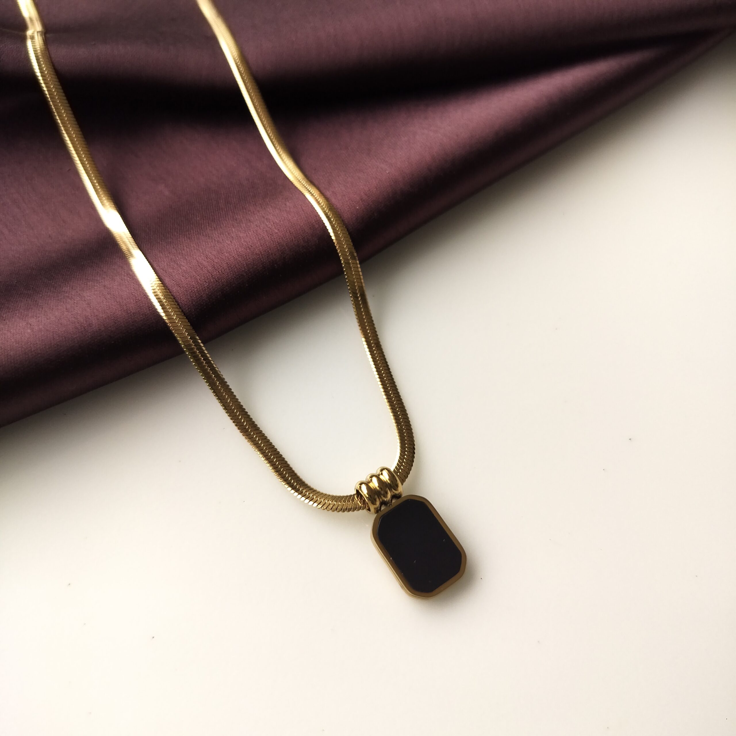 Black Obsidian Curve Necklace front view showing gold curve and black stone.