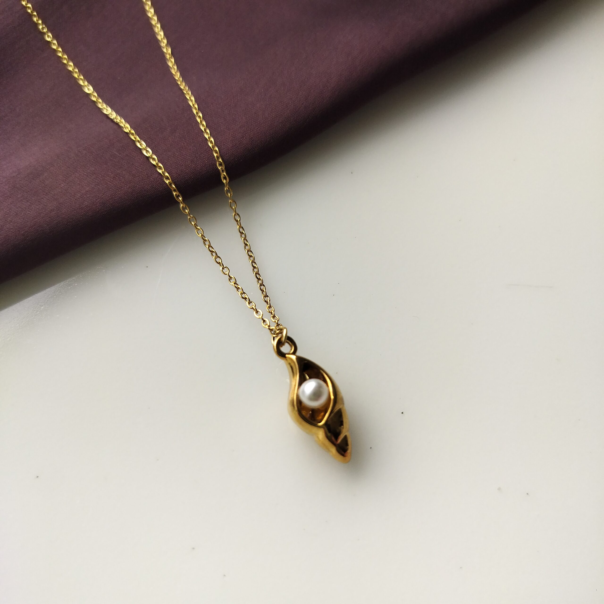 Close up of pearl inside golden conch pendant