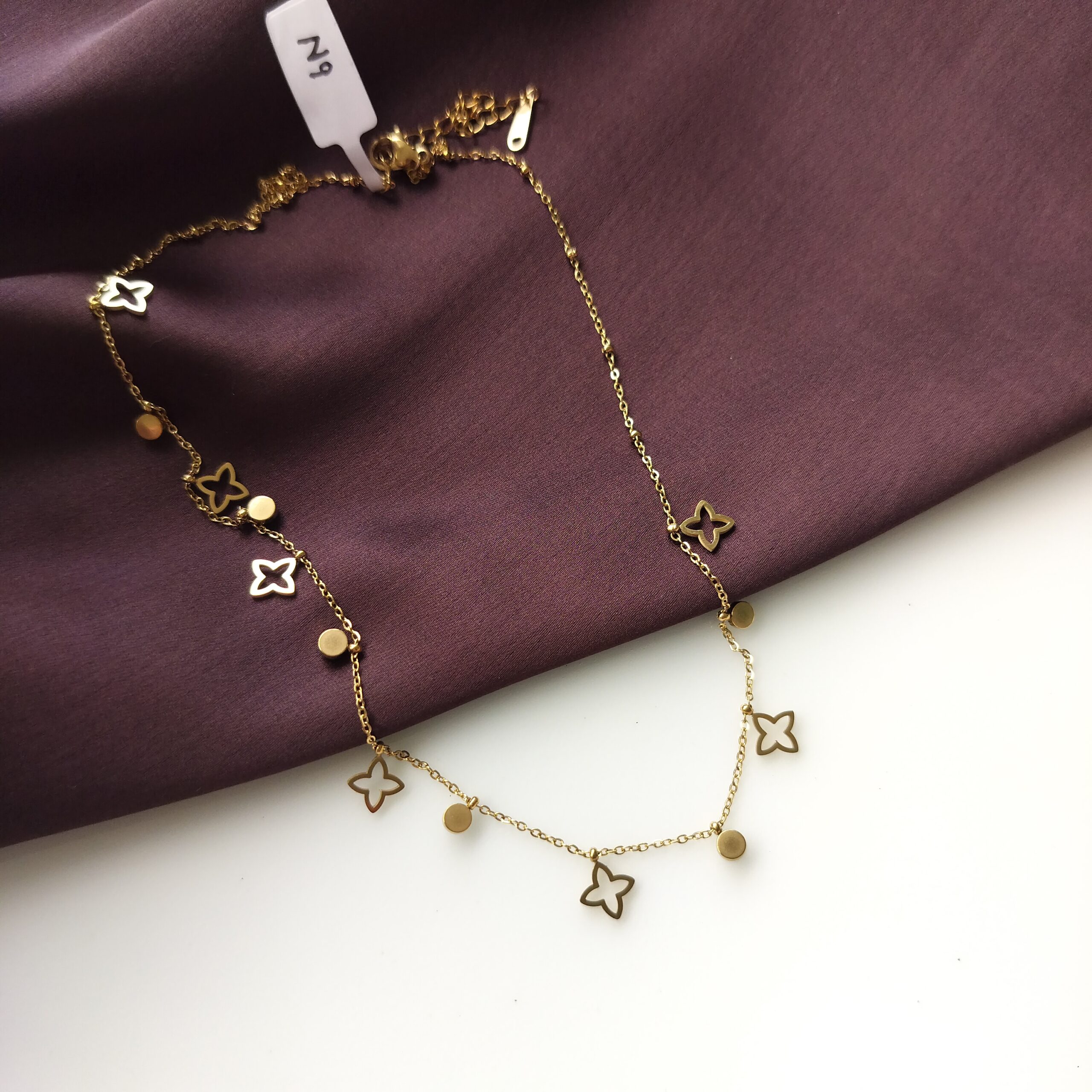 Close up of floral charms and stones on gold chain