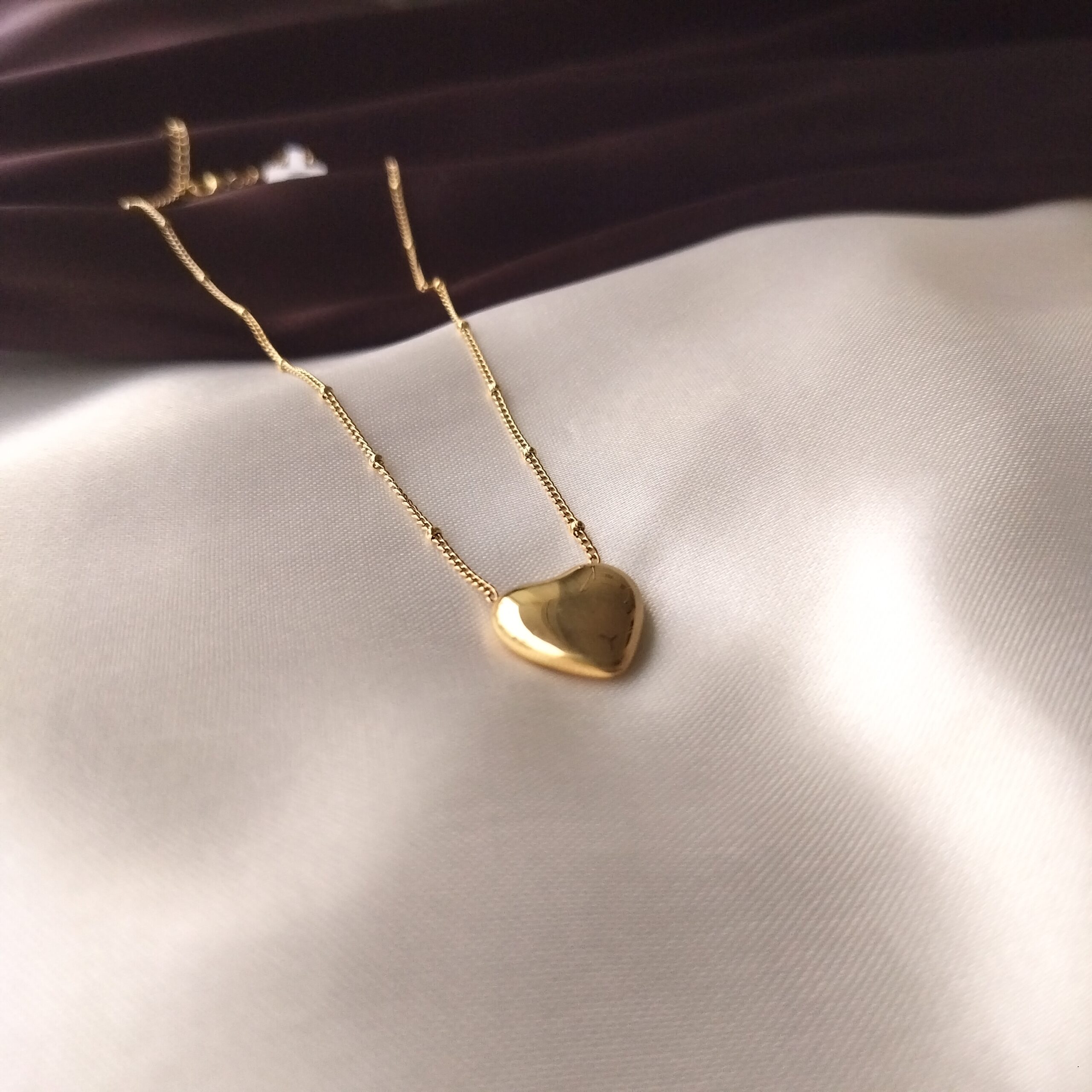 Close up detail of the gold plated heart pendant's surface.