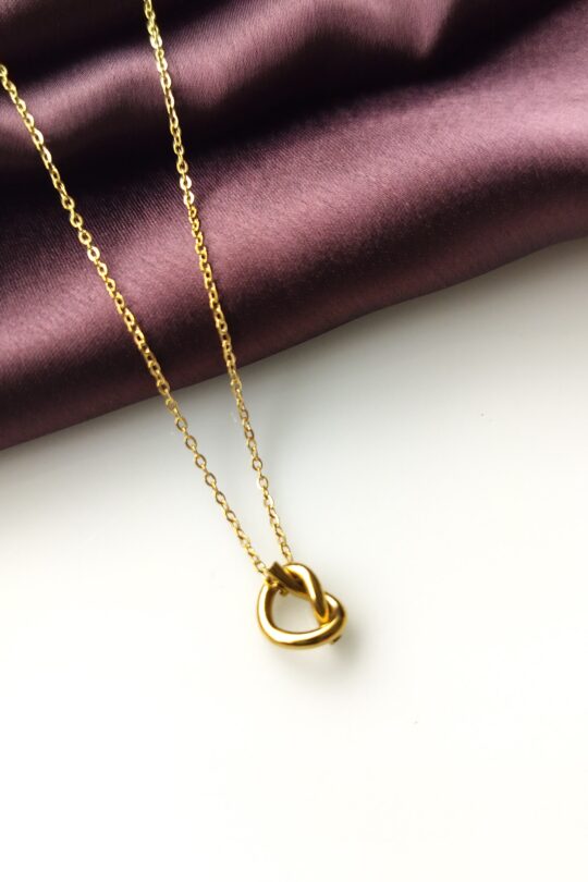 Golden Knot Pendant Necklace front view on display