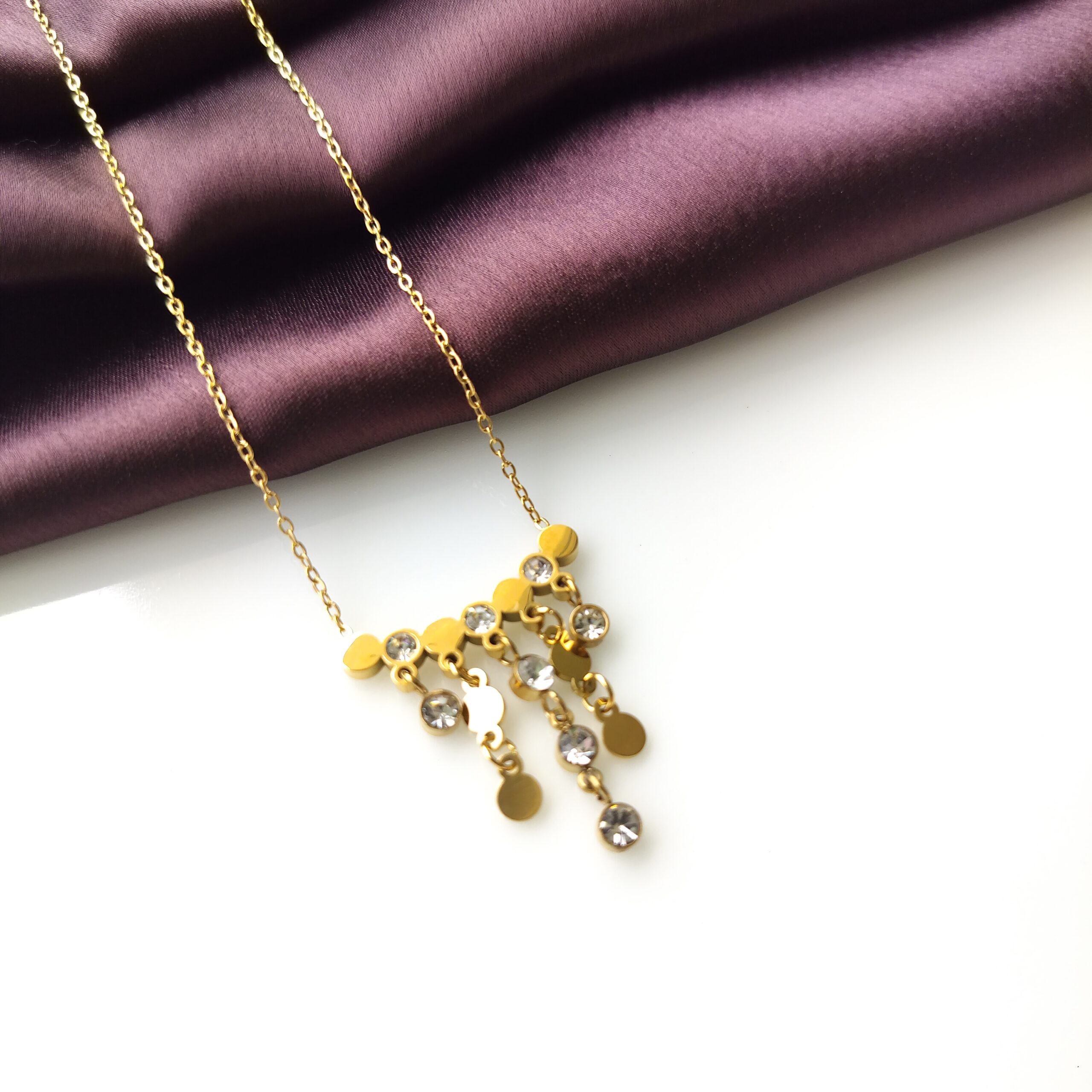 Close up detail of the gold plated hanging strings on the Rainfall necklace.