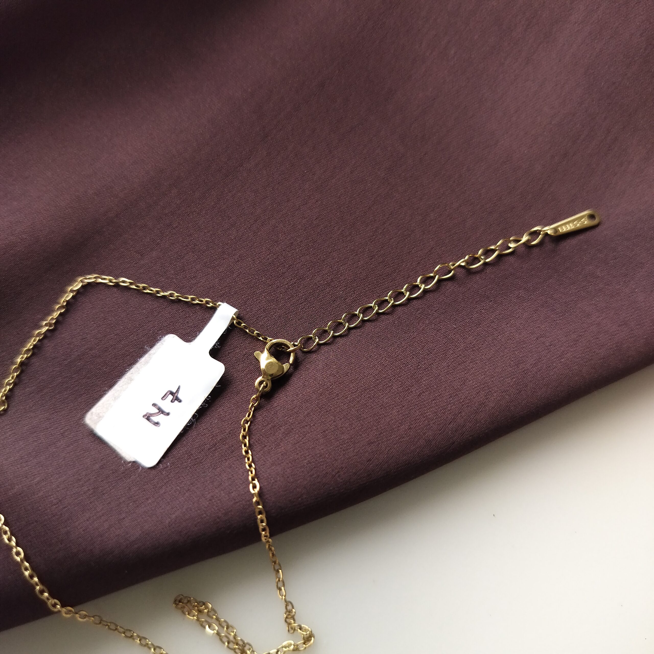 Adjusting the extra chain on the Golden Spiral Pendant Necklace.
