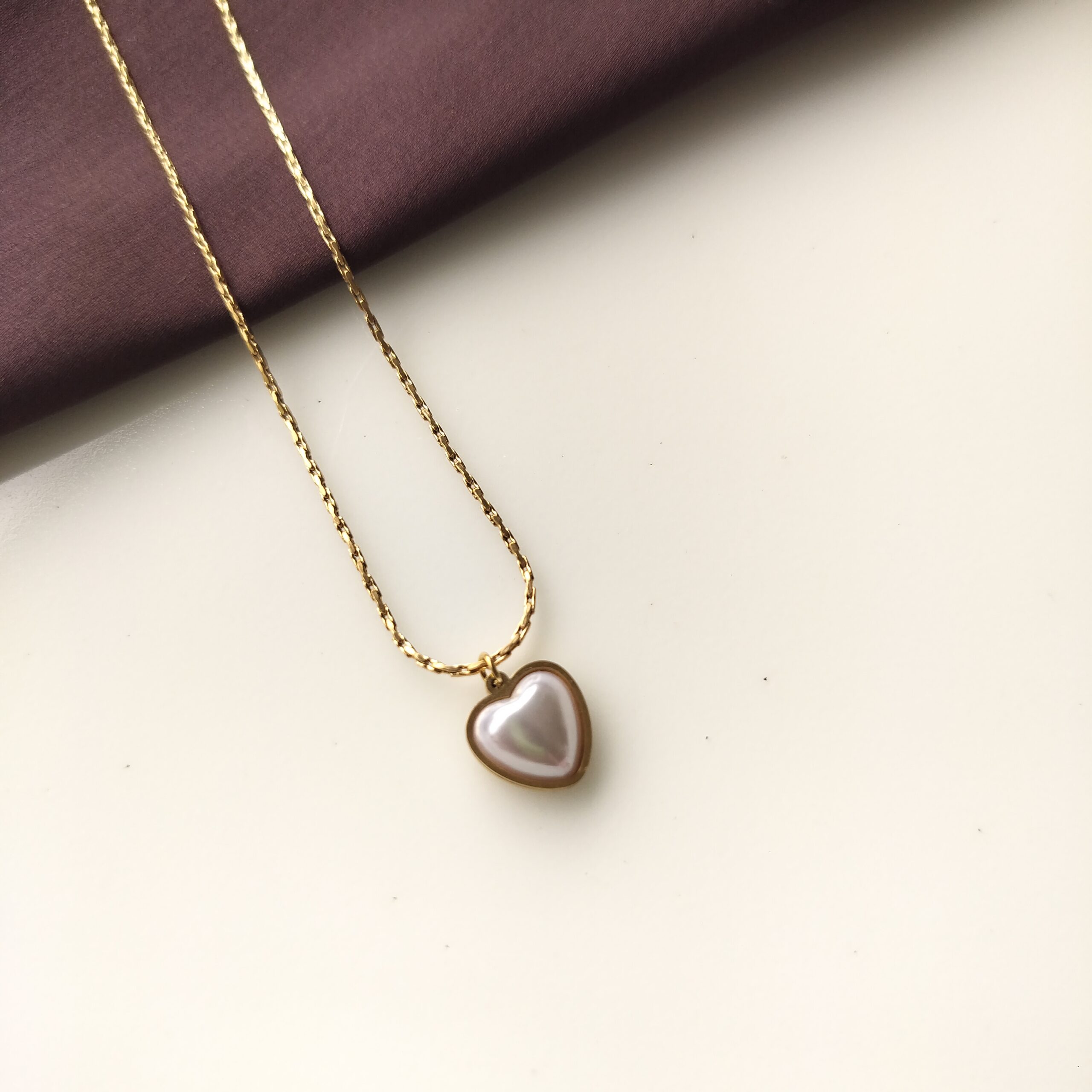 Close up of the white pearl heart in gold setting