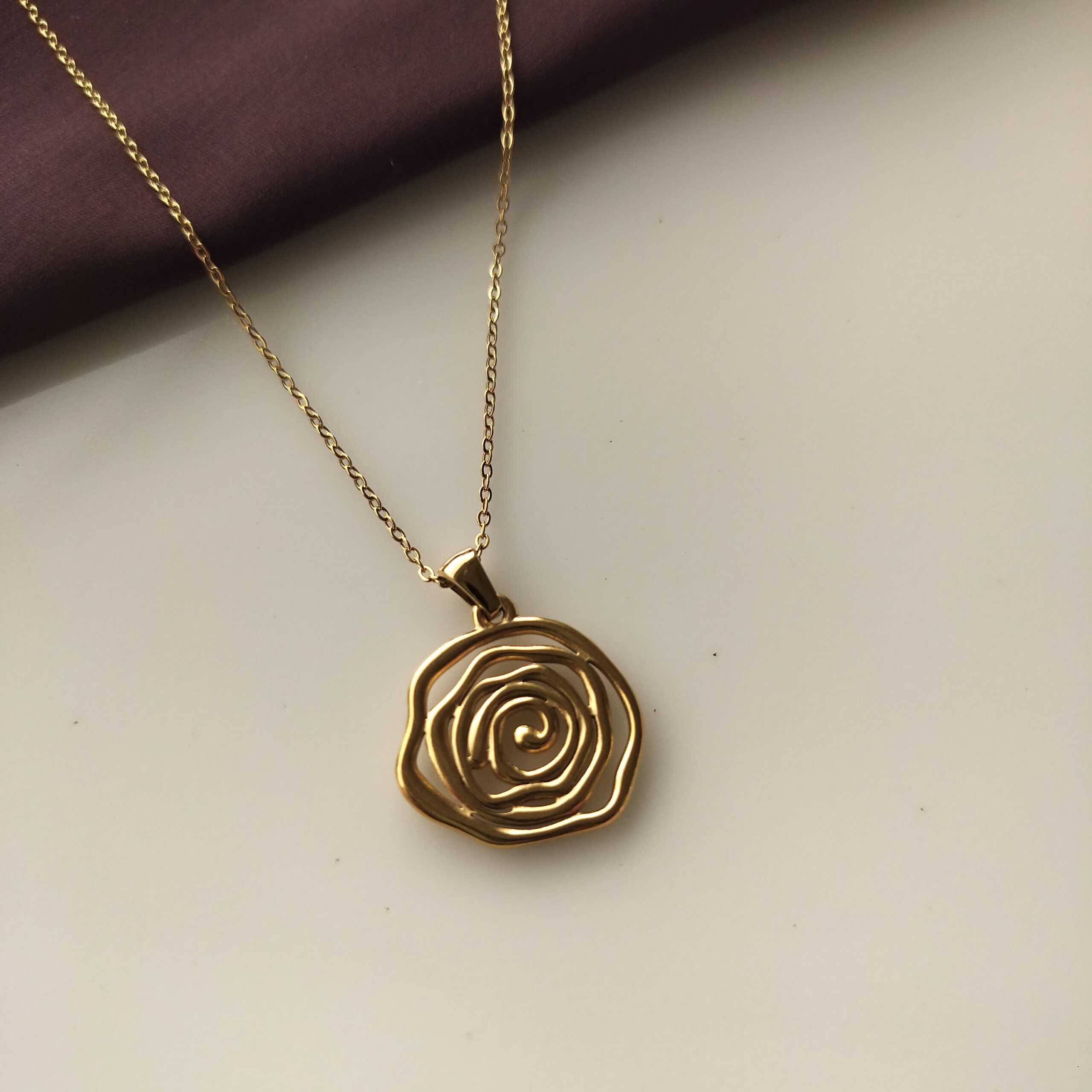 Close up of the intricate gold plated rose pendant