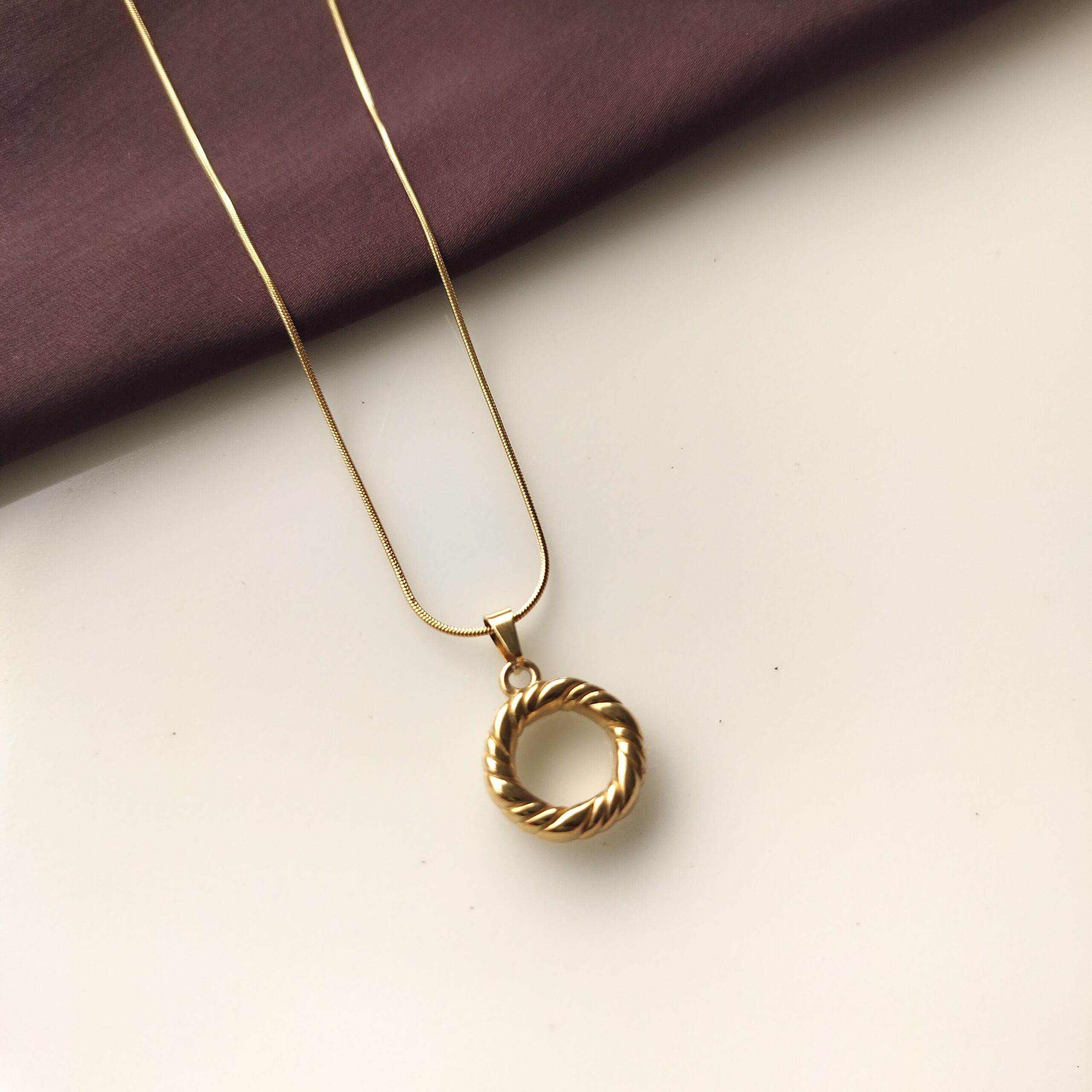 Close up of the textured surface on gold ring pendant